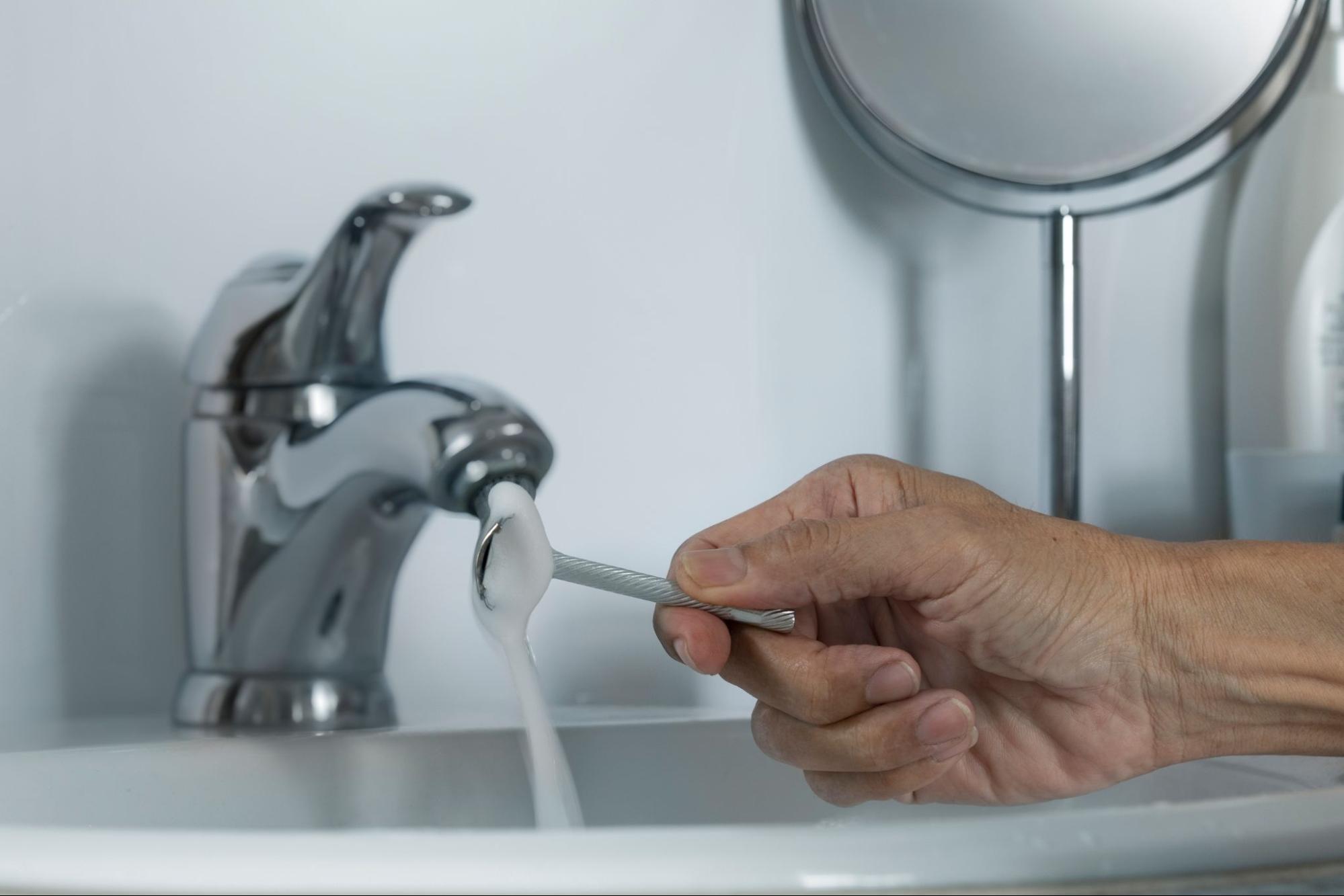 カミソリを洗う男性の手