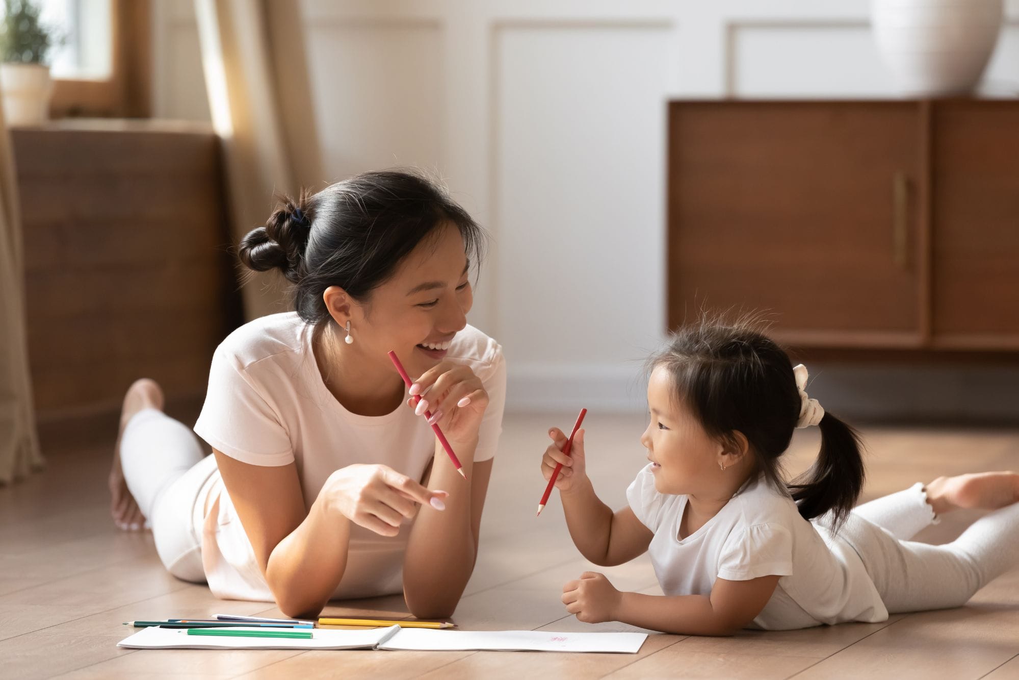 親子が鉛筆を持ってにこやかに話す