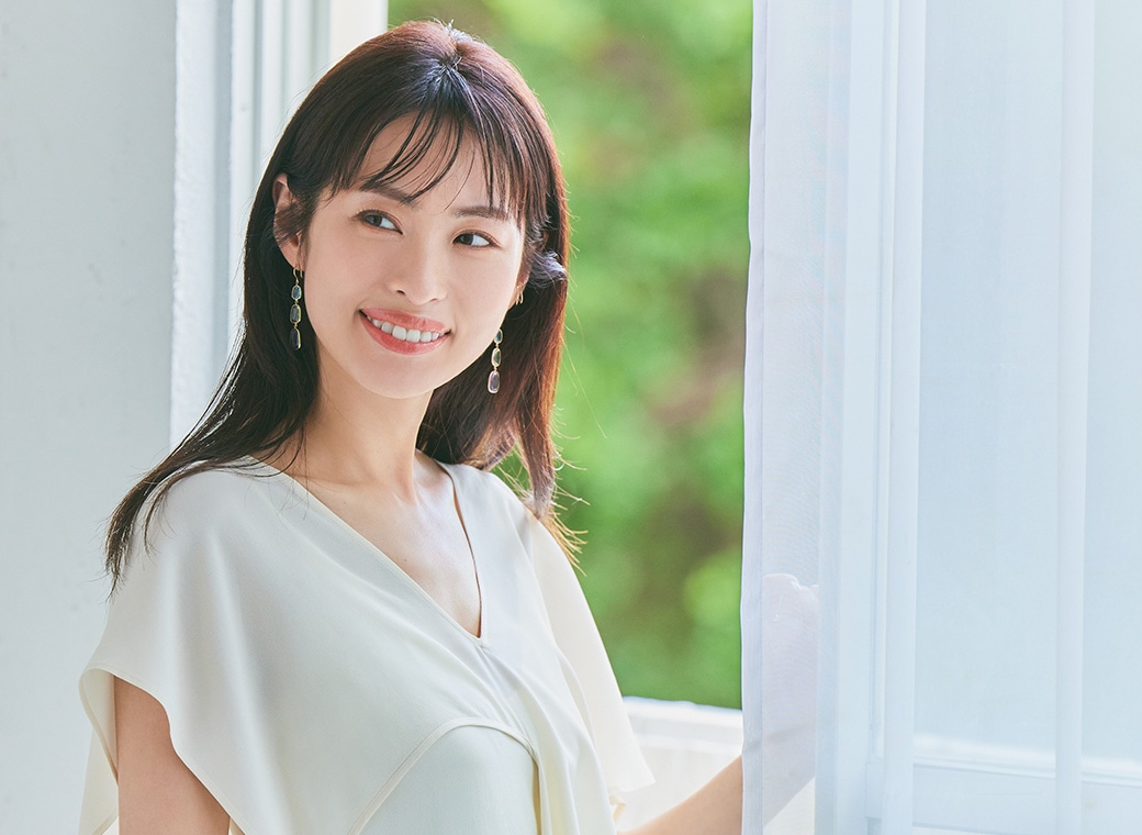 岡本静香さんがカーテン前に立つ画像