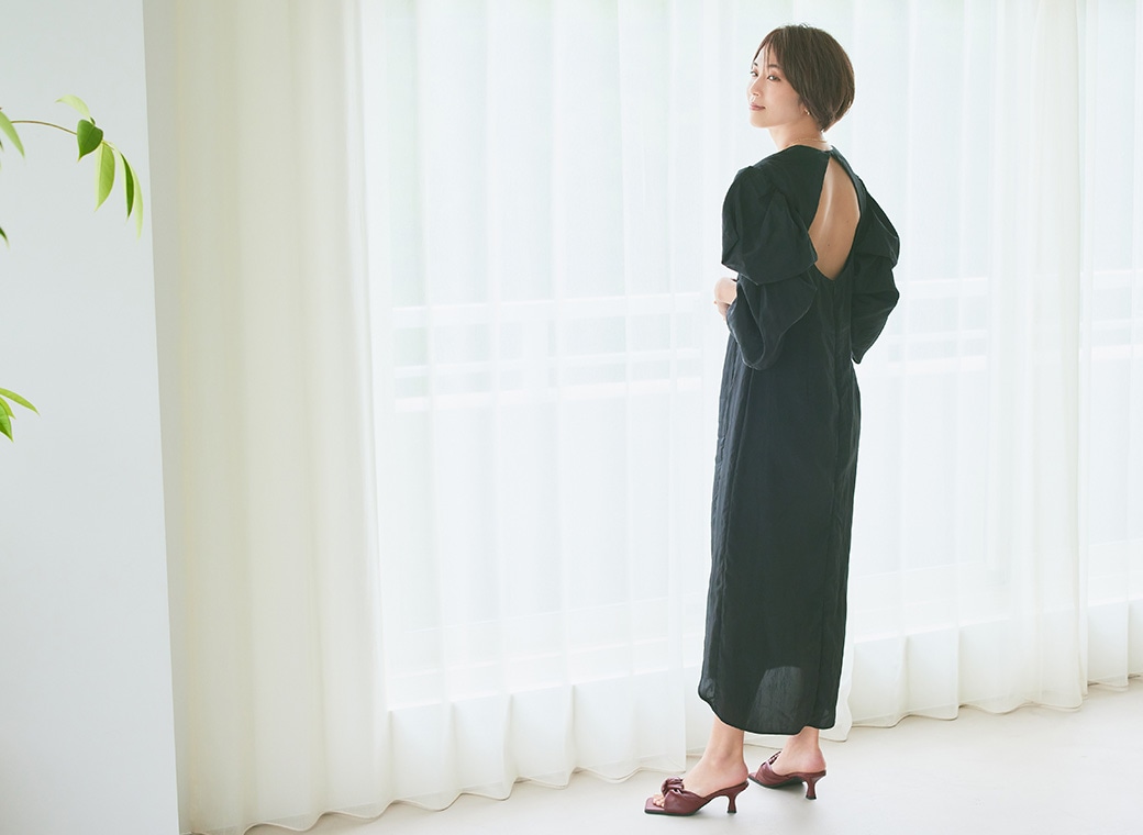 小山田早織さんがカーテン前に立つ画像