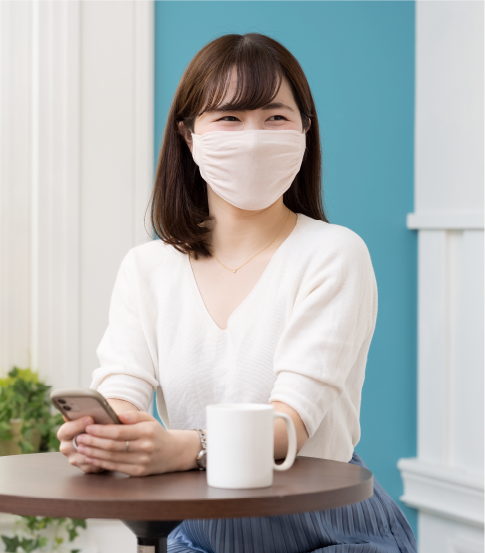 マスクをつけ座っている女性
