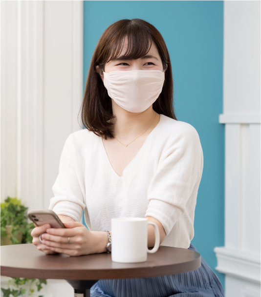 マスクをつけ座っている女性